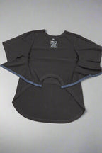 Eine schwarze, adaptive Oberteil. Assistenz beim Anziehen. Beispiel für behinderte Kleidung und Rollstuhlkleidung