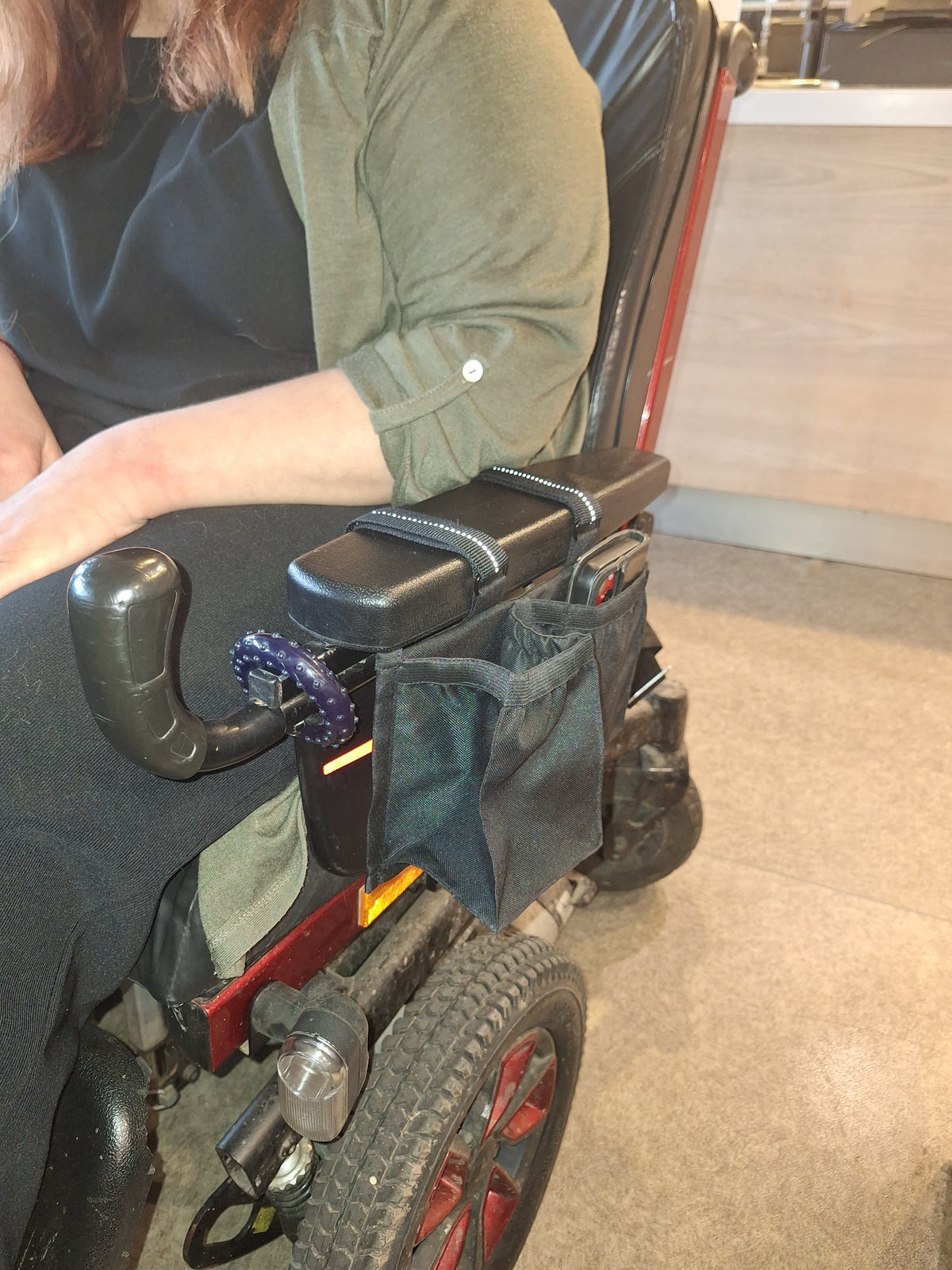 Rozā krēsla ar riteņiem roku balsta soma – krūzes turētājs